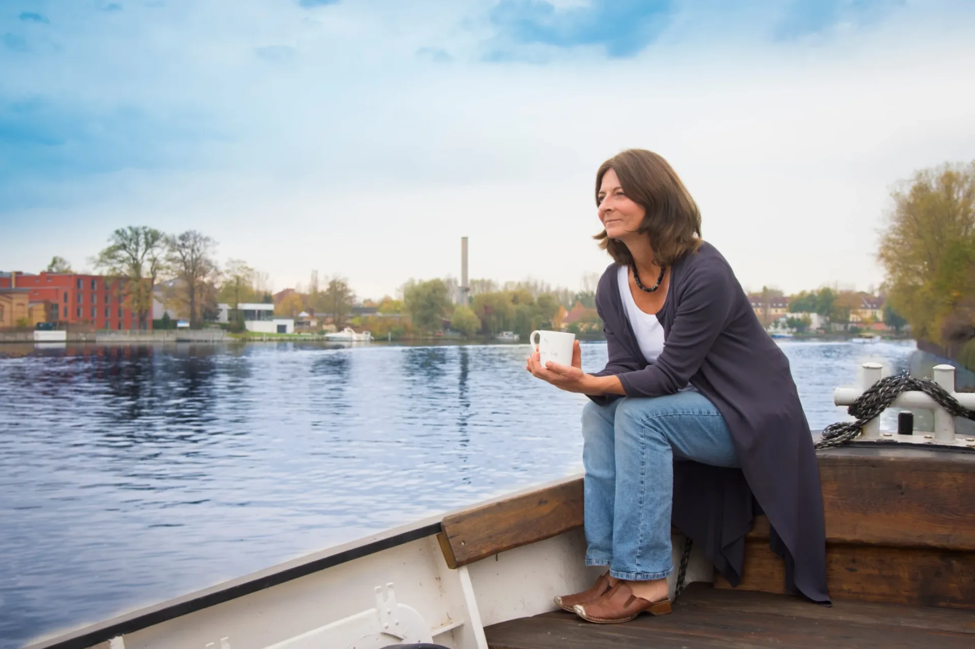 Kerstin Hack mit einer Tasse an Bord, auf der Spree in Berlin